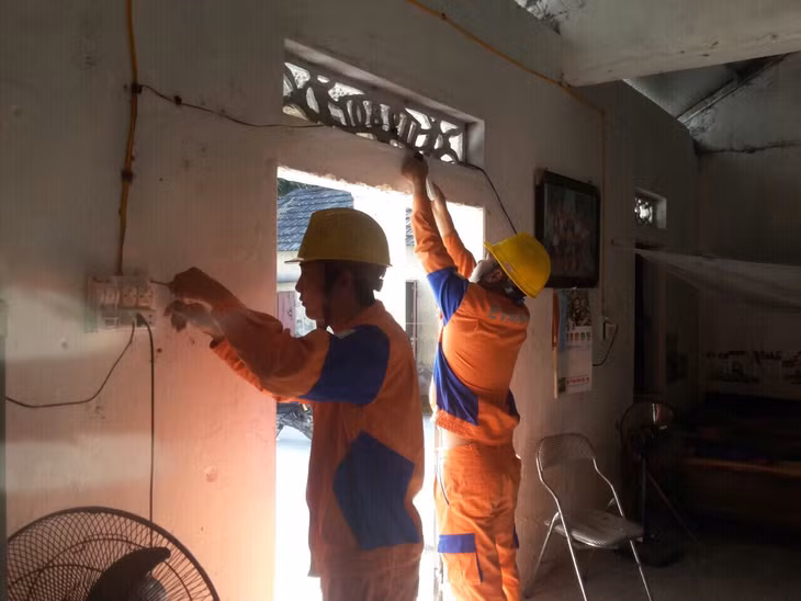 Công nhân Điện lực Đông Triều thay mới đường dây, sửa chữa bảng điện cho gia đình ông