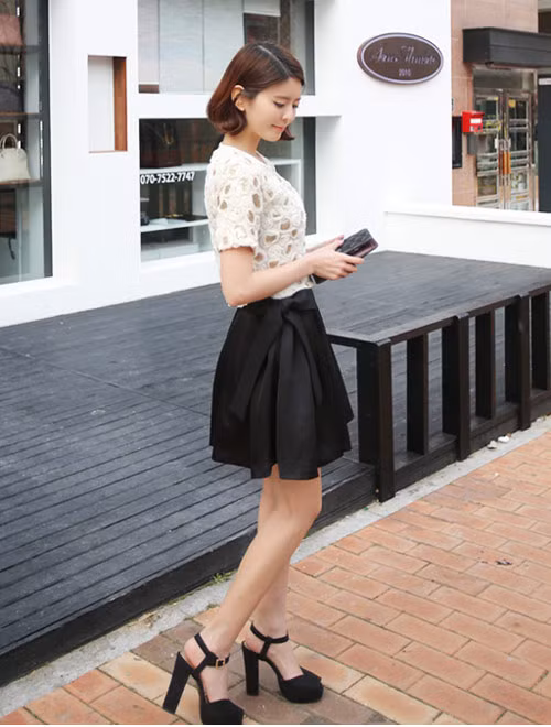 Phong cách thanh lịch của cô nàng công sở với váy xếp ly lụa và áo ren tông nude nhẹ nhàng.