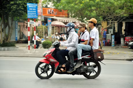 Tình trạng người đi xe máy chở quá quy định và không đội mũ bảo hiểm thường xuyên diễn ra tại TP Hạ Long. Ảnh: Nghĩa Hiếu