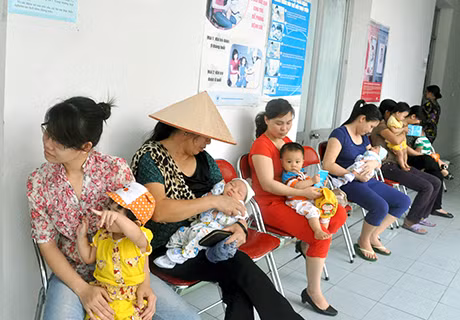 Các bà mẹ đưa con đi tiêm phòng tại Trạm Y tế phường Cao Xanh (Hạ Long) đã có ghế ngồi chờ, không còn phải đứng như những năm trước đây.
