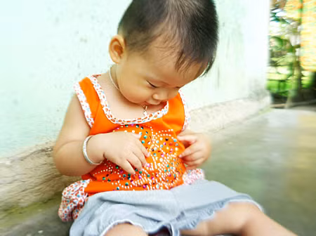 Quần áo trẻ em có đính kim loại rất nguy hiểm. Ảnh: Lê Tấn Lộc.