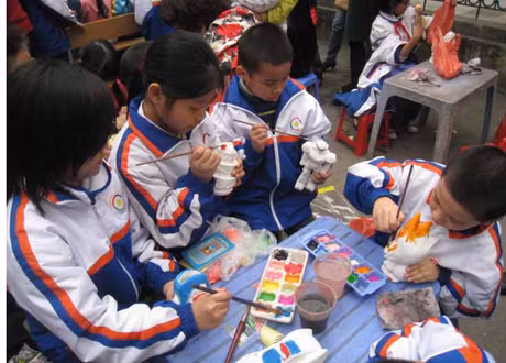 Các em học sinh tô tượng, làm tranh cát tại gian hàng nghệ thuật.