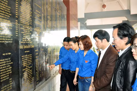 Các đoàn viên trước tấm bia ghi danh 403 liệt sĩ tại Khu di tích Căng Đồn Nghĩa Lộ.