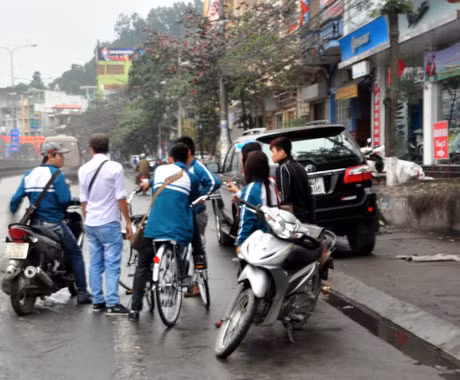 Học sinh đi xe máy để xe tại các điểm trông giữ xe bên ngoài cồng trường, tụ tập rất đông sau khi tan trường.