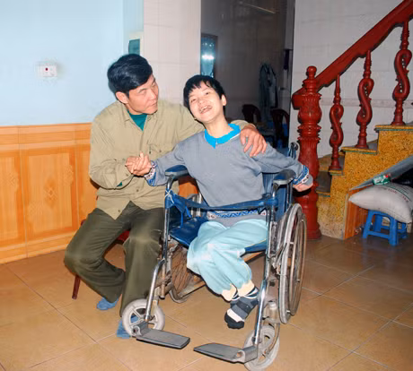 Ông Đặng Xuân Hường (bên trái), Chủ tịch Hội NNCĐ DC/Diixin phường Cẩm Phú (Cẩm Phả) thăm hỏi một nạn nhân chất độc da cam.