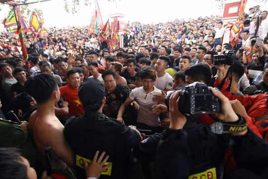Hàng trăm thanh niên đã vây kín đền thờ Thiều Hoa công chúa, nơi diễn ra lễ tế trước khi rước quả phết ra cánh đồng - Ảnh: CAND