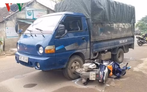 Chiếc xe máy của lực lượng CSGT nằm dưới bánh của xe tải.