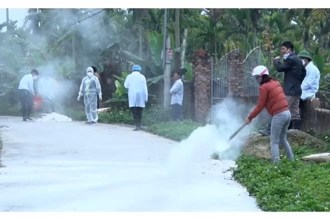 Lực lượng chức năng rắc vôi bột khử trùng khu vực nguy cơ dịch bệnh.