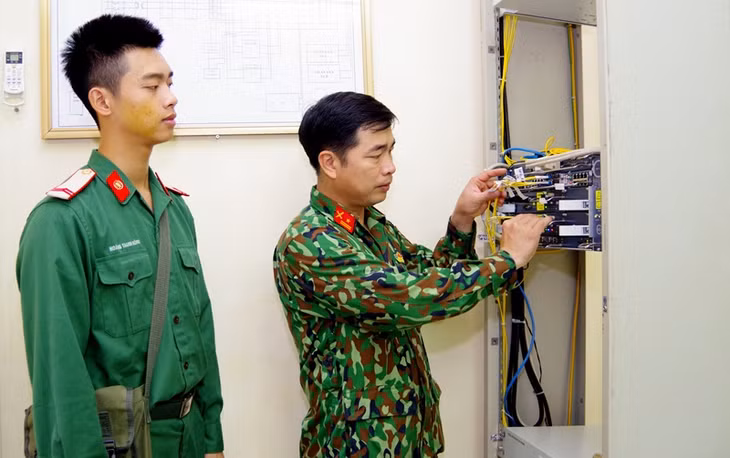  Thiếu tá Hoàng Văn Sắt (bên phải) kiểm tra tín hiệu luồng thông tin.