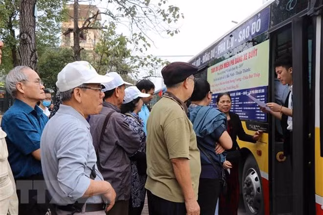 Du khách xếp hàng lên xe buýt du lịch miễn phí tại điểm đón thành phố Bắc Ninh. (Ảnh: Diệp Trương/TTXVN)