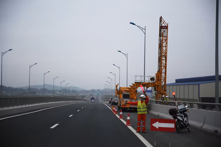 Công nhân Công ty CP Xây dựng và Thương mại 909 phát tín hiệu để các phương tiện lưu thông an toàn khi tiến hành kiểm tra tuyến 