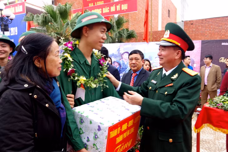 Đái tá Lê Đình Thương, UVBTV Tỉnh ủy, Chỉ huy trưởng Bộ CHQS tỉnh, Phó Chủ tịch Thường trực HĐNVQS tỉnh Quảng Ninh tặng hoa động viên thanh niên TP Hạ Long lên đường nhập ngũ.