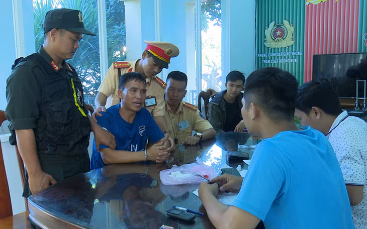  Đối tượng Lữ (mặc áo xanh, đeo còng) cùng số ma túy tang vật trước lực lượng công an
