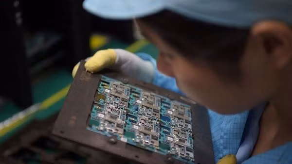 Một công nhân lắp ráp linh kiện điện thoại tại nhà máy ở Đông Quản, Trung Quốc. Ảnh: AFP.