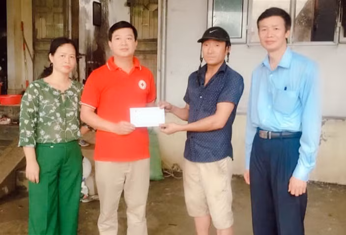 Ông Phạm Văn Thơ (áo đỏ) Chủ tịch Hội CTĐ TP Hạ Long trao hỗ trợ cho gia đình ông Lê Văn Hậu, tổ 64, khu 7, phường Cao Thắng do nhà bị hỏa hoạn.