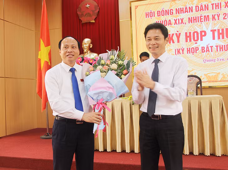 Ông Hồ Văn Vịnh, Bí thư Thị ủy, tặng hoa chúc mừng ông Vũ Đức Hưởng, tân Chủ tịch HĐND thị xã.