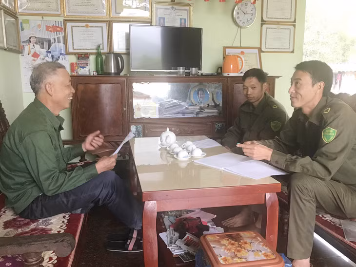 Ông Tằng Sinh Pẩu (bên trái) đang bàn với lực lượng công an xã về cách tuyên truyền pháp luật cho người dân