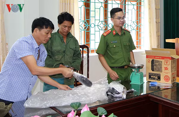  Đối tượng Giàng A Và (giữa) cùng tang vật tại cơ quan Cảnh sát điều tra