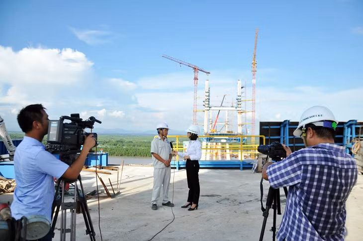 Phóng viên Trung tâm truyền thông tác nghiệp trên công trường xây dựng cầu Bạch Đằng. 