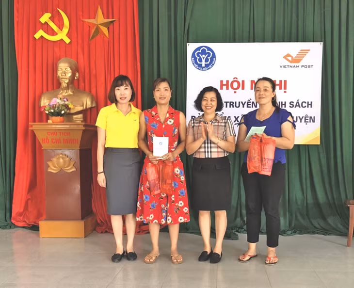 BHXH huyện Hoành Bồ trao sổ BHXH tự nguyện cho người dân tham gia tại xã Thống Nhất. Ảnh: Thu Hồng (BHXH Hoành Bồ).