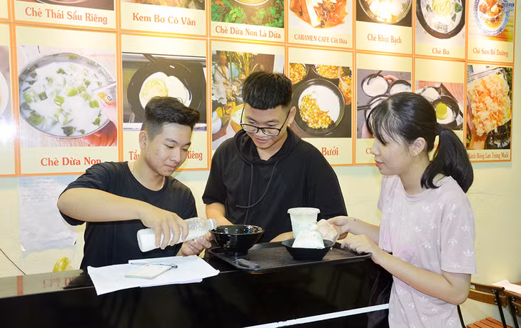 Em Nguyễn Xuân Hiếu, ngoài cùng bên trái lấy chè cho khách.