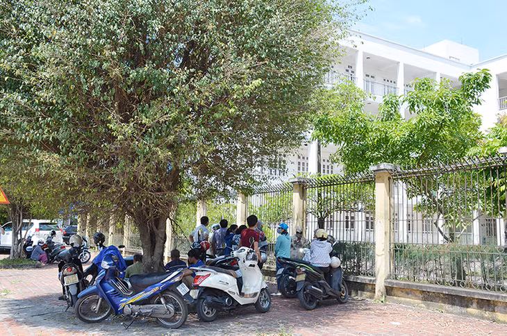 Các bậc phụ huynh tìm những chỗ râm mát để chờ con làm bài thi.