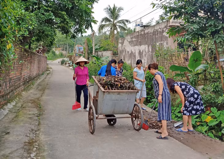 Cô Hoàng Thị Hiền khu 8, Thị trấn Trới, huyện Hoành Bồ (Áo tím) cùng chị em phụ nữ trong khu dọn vệ sinh ngõ xóm. 
