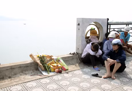 Người nhà anh Biên đang thất thần ngồi trên cầu, nơi anh Biên bị tan nạn chờ đợi! 