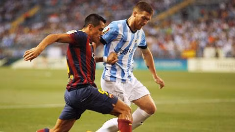 Barca (trái) nhọc nhằn giành 3 điểm trên sân của Malaga