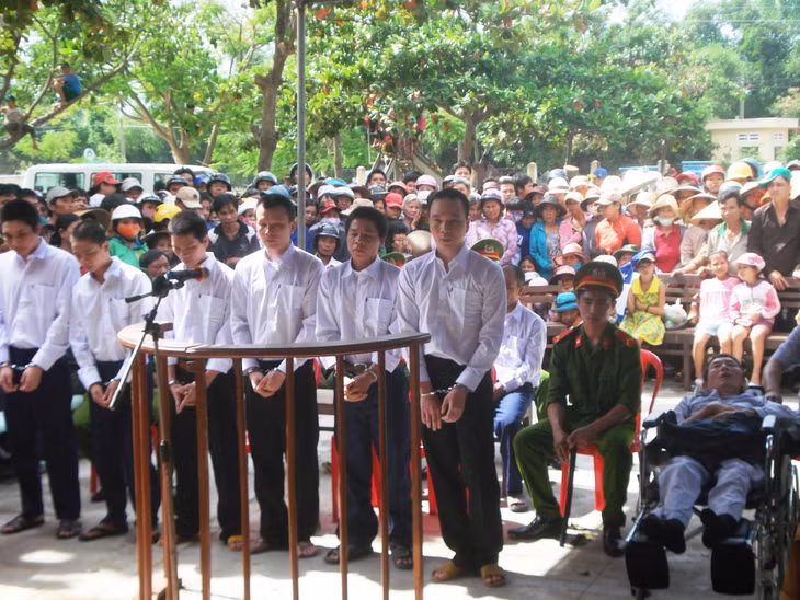 Các bị cáo tại phiên tòa. Nạn nhân Đạt được mọi người đẩy tới tòa bằng xe lăn. Ảnh: Danh Toại