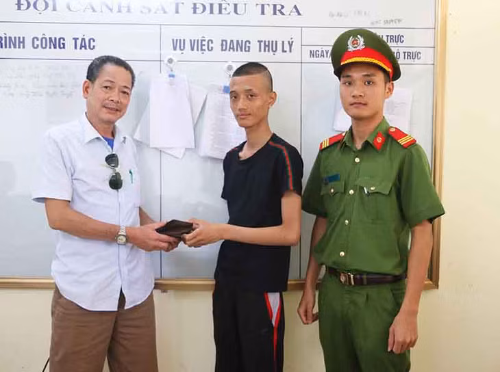 Anh Nguyễn Văn Nam (áo đen) trao trả lại ví tiền cho ông Phùng Đình Chiến trước sự chứng kiến của CBCS Công an huyện Cô Tô.