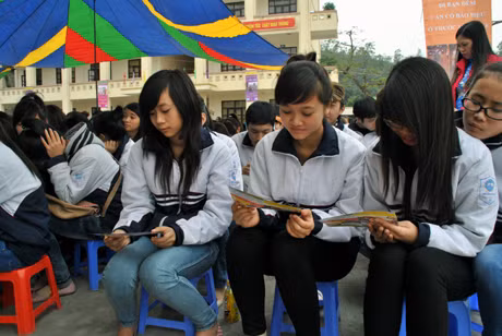 Học sinh Trường THPT Ngô Quyền (TP Hạ Long) đọc tờ rơi tuyên truyền về ATGT.