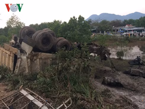 Sau cú đâm, xe tải lật úp xuống ven đường sắt và bị bẹp dúm dó.
