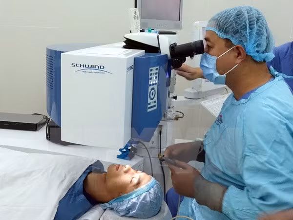 Bác sỹ Bệnh viện Mắt Thành phố Hồ Chí Minh thực hiện ca phẫu thuật khúc xạ mắt bằng ​laser công nghệ SmartSurfACE cho bệnh nhân. (Ảnh: Phương Vy/TTXVN)