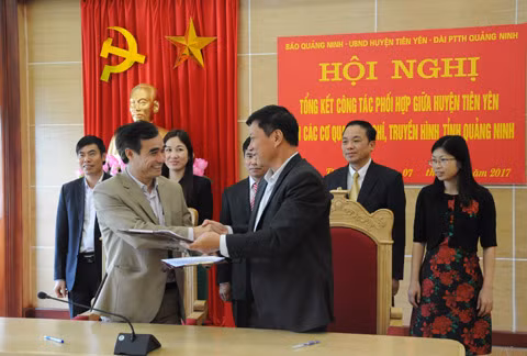 2 đồng chí Hoàng Chí Dũng, Phó Tổng Biên tập Báo Quảng Ninh (bên trái) và Hoàng Mạnh Hưng, Phó Chủ tịch UBND huyện Tiên Yên ký kết văn bản phối hợp tuyên truyền năm 2017