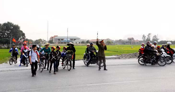 Ông Phạm Đức Hạnh dẫn học sinh sang đường giờ tan học.