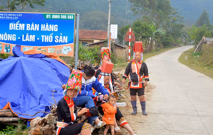 Chị em phụ nữ người Dao Thanh Phán, xã Đồng Văn ngồi thêu thổ cẩm ngay bên đường. 