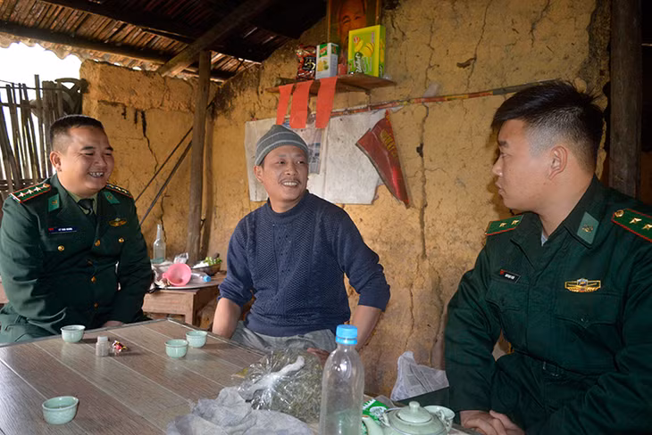 Trưởng bản Phạt Chỉ Dường A Tài tiếp chuyện các chiến sĩ biên phòng ghé thăm nhà.