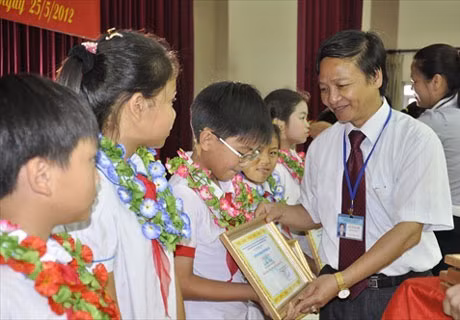 Đồng chí Lưu Xuân Giới, Trưởng Phòng GD-ĐT huyện Đông Triều trao phần thưởng cho học sinh xuất sắc của huyện năm học 2011-2012.