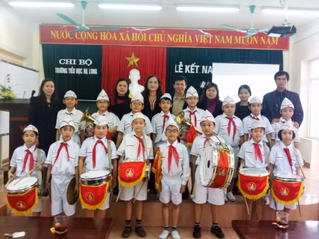 Thầy giáo Nguyễn Hữu Hùng (đứng sau, ngoài cùng bên phải) cùng các đồng nghiệp ở Cung VHTN QN chụp ảnh lưu niệm với các em thiếu nhi trong Đội nghi thức của Trường Tiểu học Hạ Long.