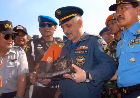 Các quan chức Nga và Indonesia cầm một phần hộp đen của SSJ-100 tại căn cứ tìm kiếm cứu hộ ở Cijeruk, gần núi Salak. Ảnh: AFP