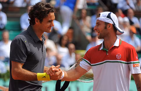 Federer sau khi lập kỷ lục 234 trận thắng ở Grand Slam, bắt tay đối thủ Adrian Ungur.