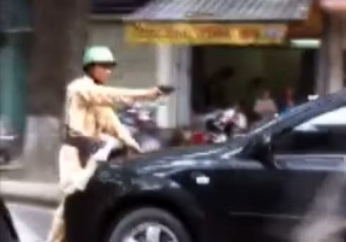 Mặc cho cảnh sát nổ súng thị uy, tài xế vẫn cho xe chạy. Ảnh chụp từ clip.