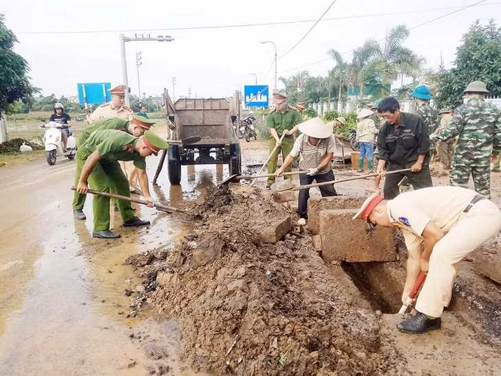 Công an TX Đông Triều giúp dân thôn Đoàn Xá 2, xã Hồng Phong dọn vệ sinh môi trường.