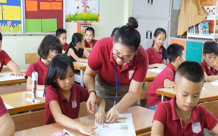 Cô giáo tỉ mỉ hướng dẫn từng em học sinh bọc vở bằng giấy