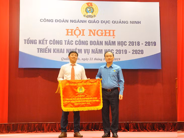 Lãnh đạo LĐLĐ tỉnh tặng cờ thi đua cho Trường THPT Nguyễn Bình.