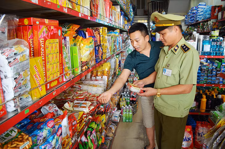 Cán bộ Đội QLTT số 2 kiểm tra việc kinh doanh bánh trung thu của một cửa hàng trên địa bàn thị trấn Cái Rồng 