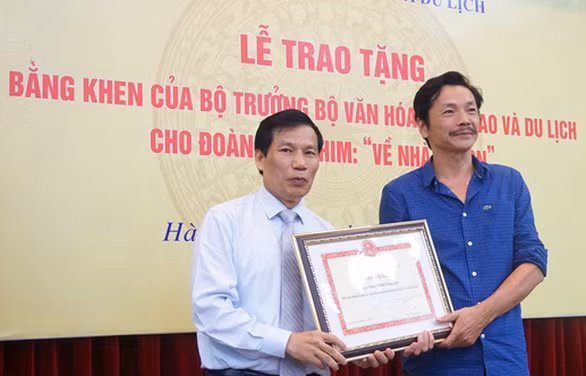 Bộ trưởng Nguyễn Ngọc Thiện trao bằng khen cho diễn viên Trung Anh - Ảnh: NGỌC DIỆP