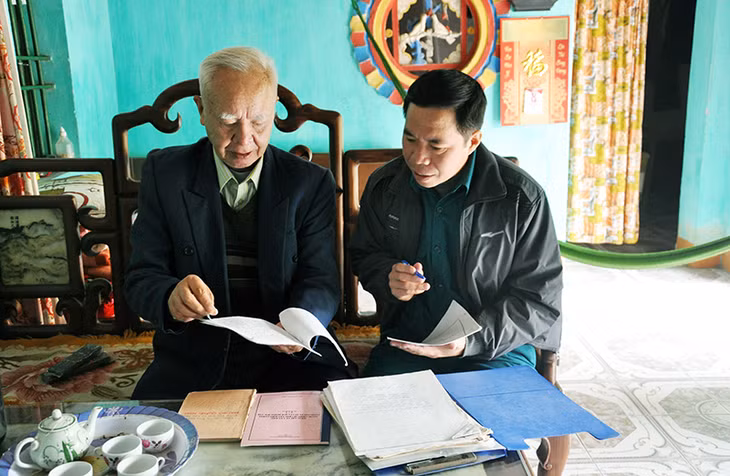 Ông Vũ Ngọc Điều, cán bộ tuyên giáo Đảng ủy xã Hải Anh, huyện Hải Hậu tìm tập tài liệu lịch sử ghi chép về thân thế, sự cống hiến của người Anh hùng Vũ Văn Hiếu.