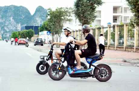 Học sinh đi xe máy điện dàn hàng ngang ra đường. (Ảnh chụp hồi 16 giờ 30 ngày 25-5-2015 cạnh trường THPT Chuyên Hạ Long).